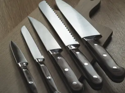 cinco facas em uma tábua de corte