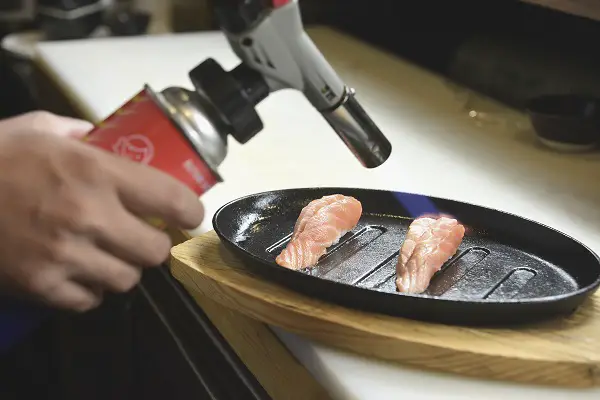 Maçarico culinário grelhando sushi de salmão - como usar maçarico culinário

